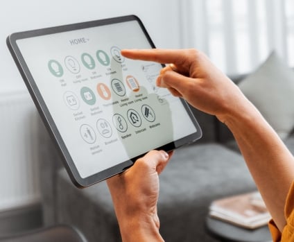 a woman using smart home controls on a digital tablet.