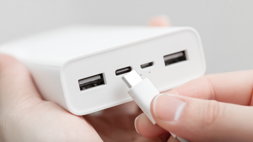 Hand inserting usb type-c connector into powerbank