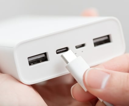 Hand plugging a USB type-c cable into a power bank.